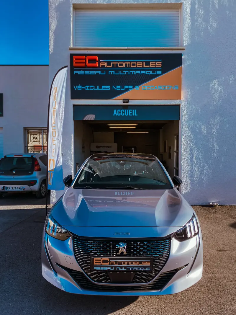 La façade du garage avec une Peugeot 208 devant l'accueil