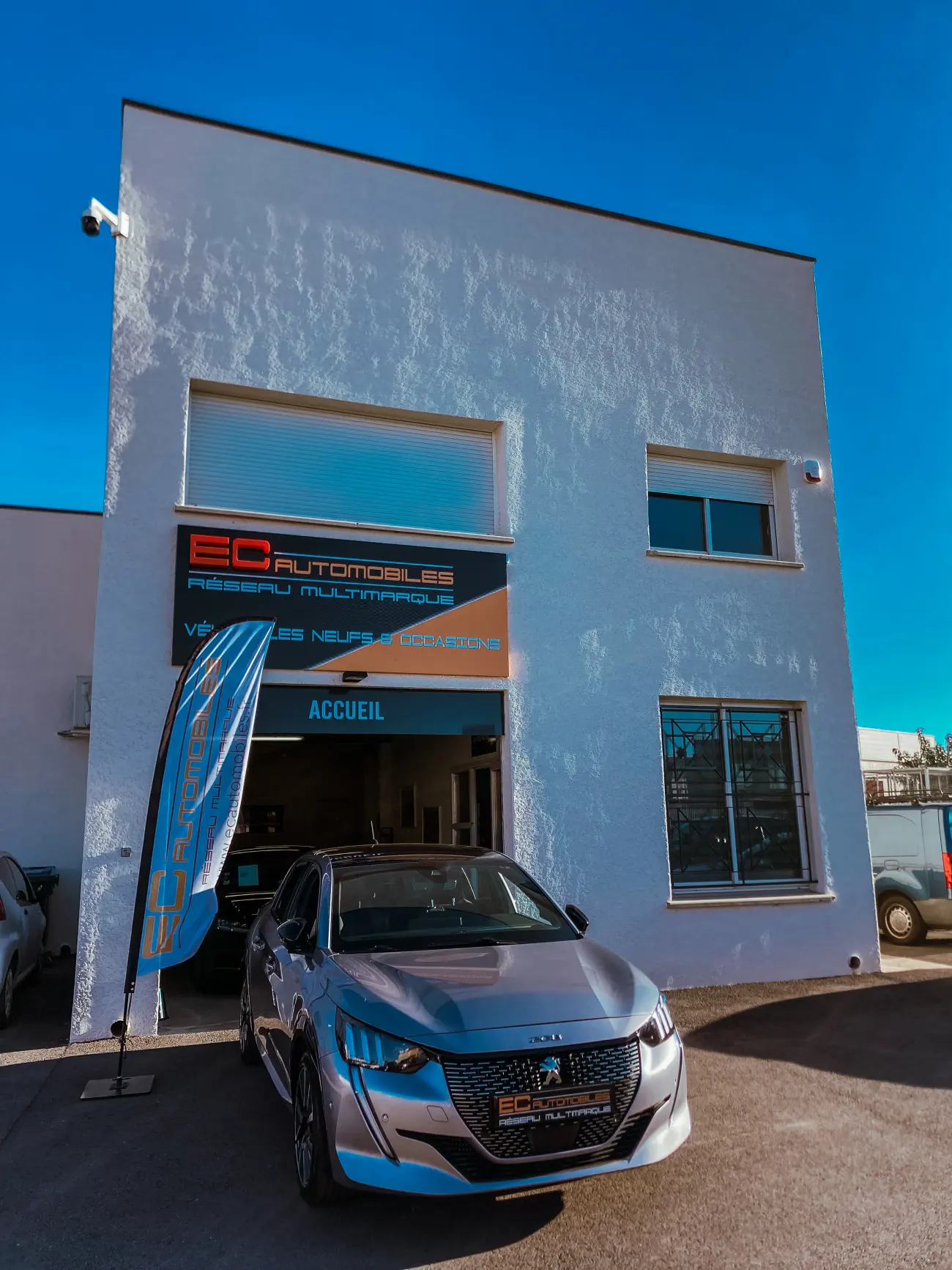 La façade d'EC Automobiles à Mauguio, avec une Peugeot 208 devant l'entrée