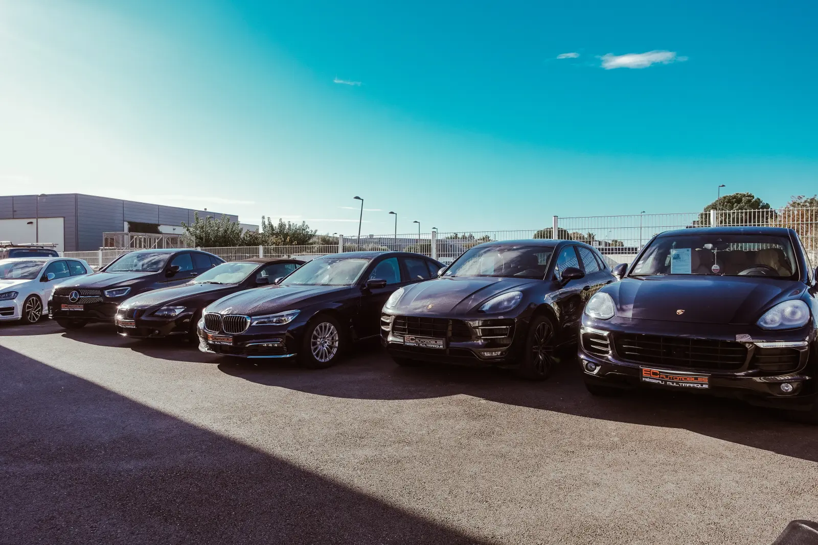 Le parc d'EC Automobiles à Mauguio : des BMW, des Porsche et des SUV alignés sous un ciel bleu