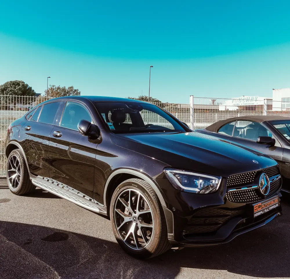 Un Mercedes GLC noir devant un ciel bleu